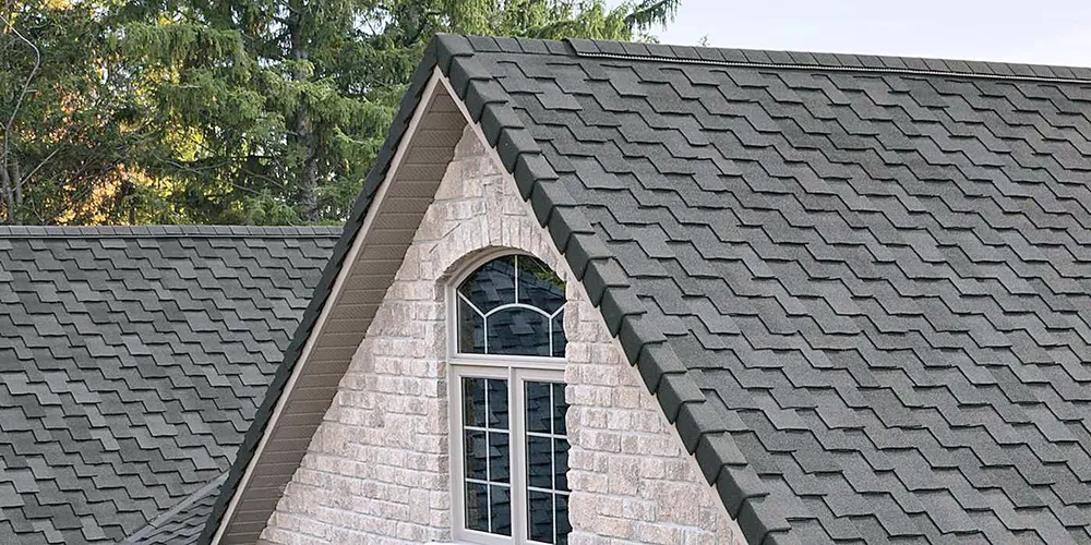 A front gable with an arched window under a dark shingle roof